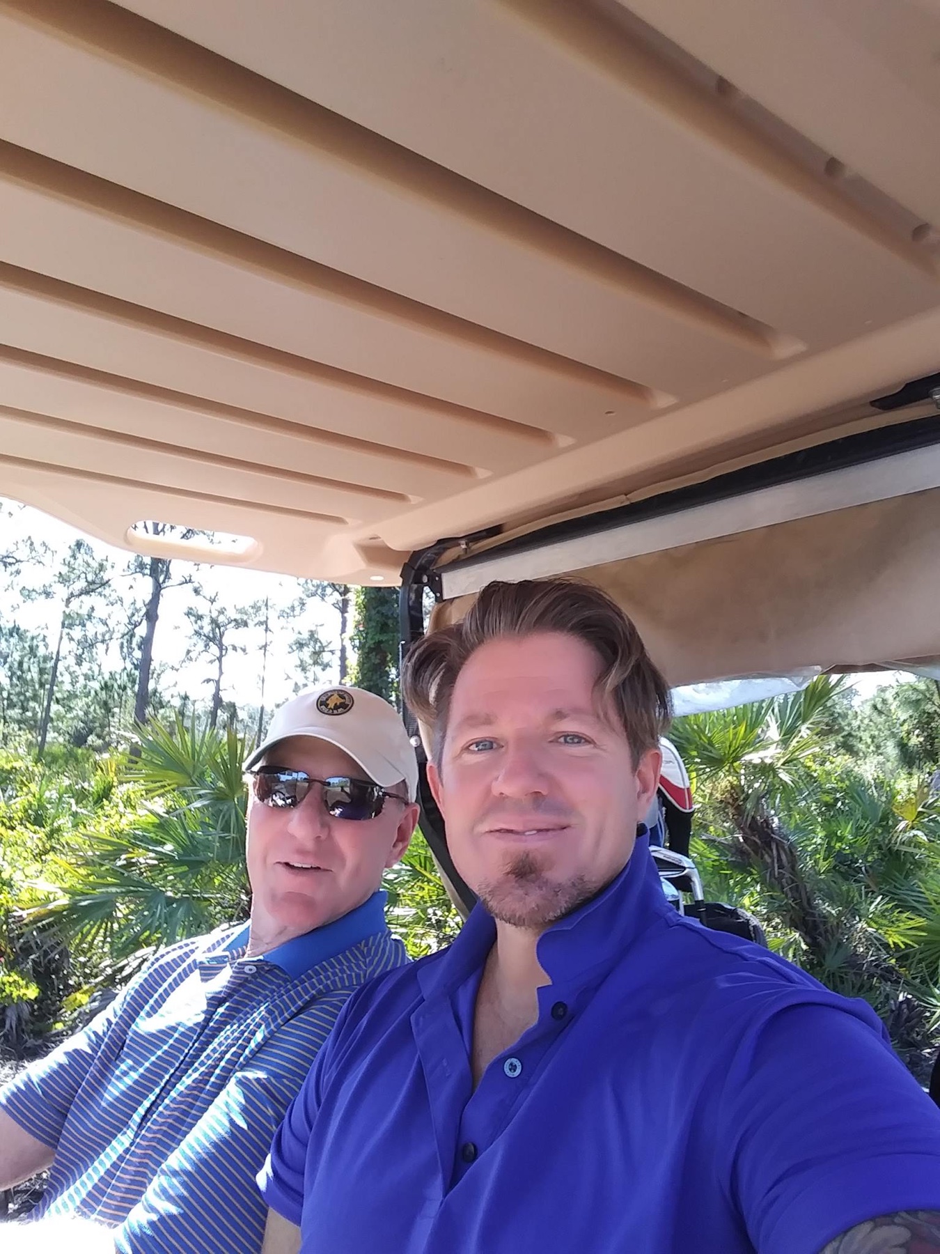 Brian riding in a golf cart with family